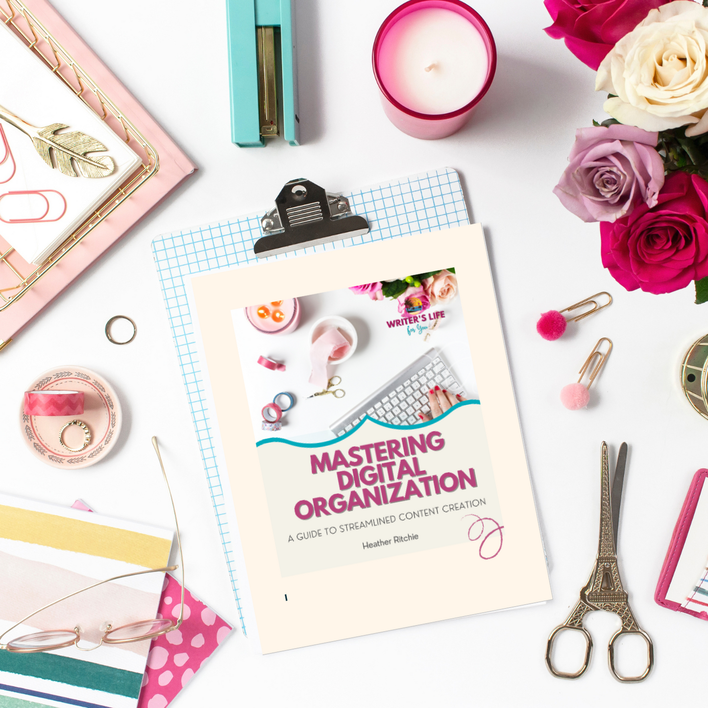 A styled flat lay featuring "Mastering Digital Organization" by ContentPreneur Biz Shop on a clipboard captures the essence of a well-organized digital workspace. The arrangement, complete with surrounding items such as flowers, paper clips, a lit candle, binder clip, and pink-striped notepad, inspires effortless content creation.