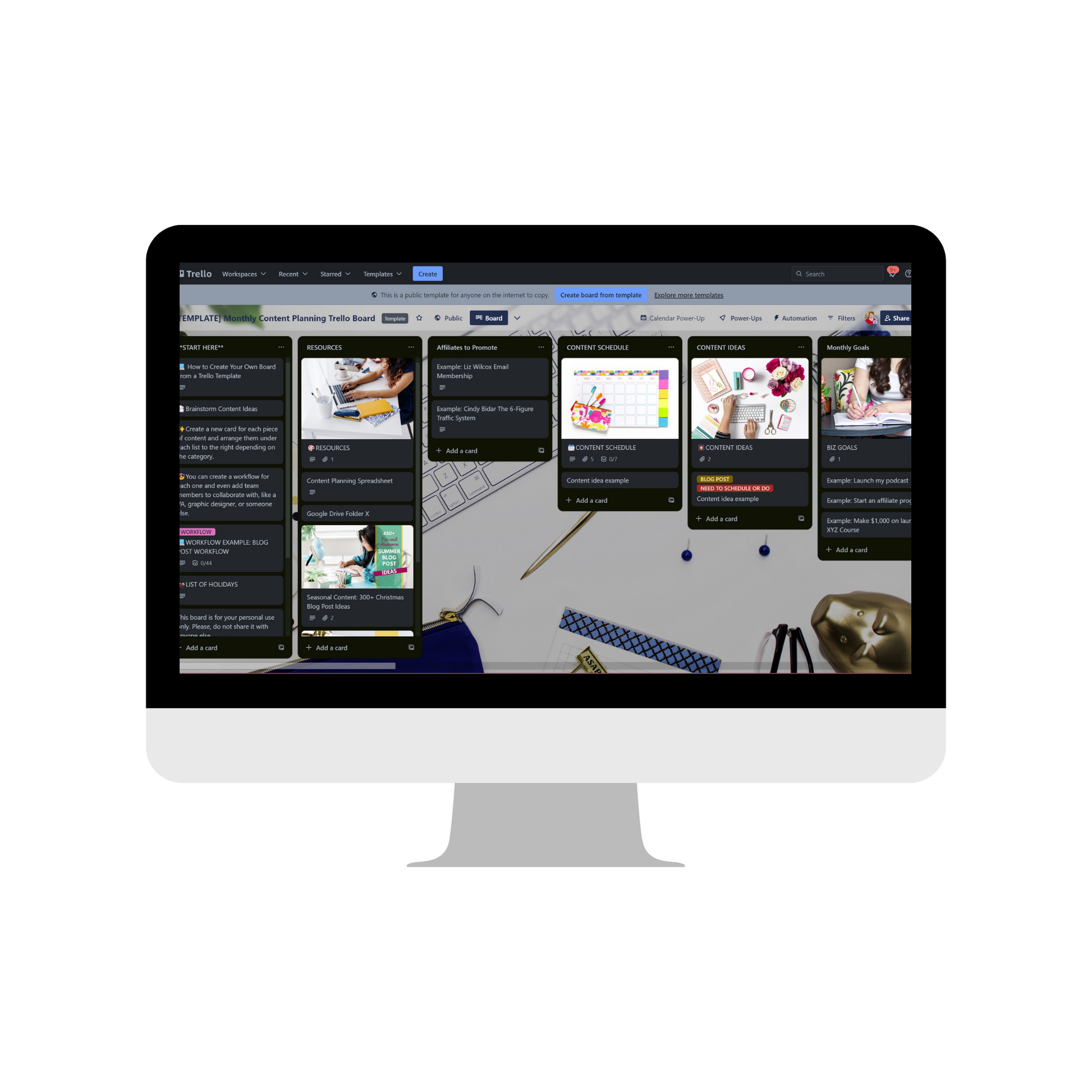 A ContentPreneur Biz Shop's Content Catalyst SEO Hub is showcased on a computer monitor with multiple lists and cards, surrounded by office supplies such as pens and clips. This hub, vital for planning content creation, features notes, schedules, and tasks—ideal for leveraging audience insights.